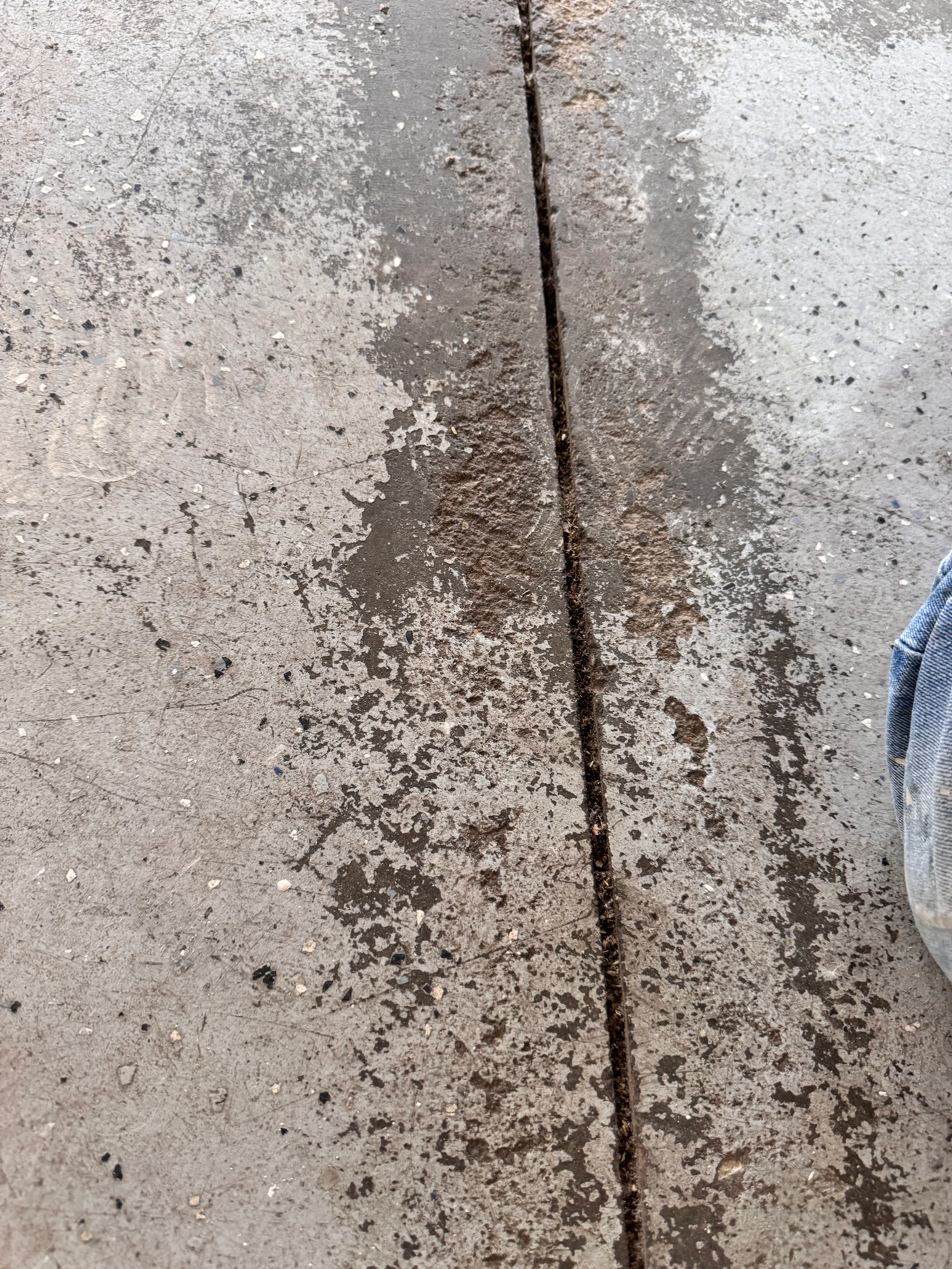 Concrete floor with vertical crack and surface deterioration before epoxy repair