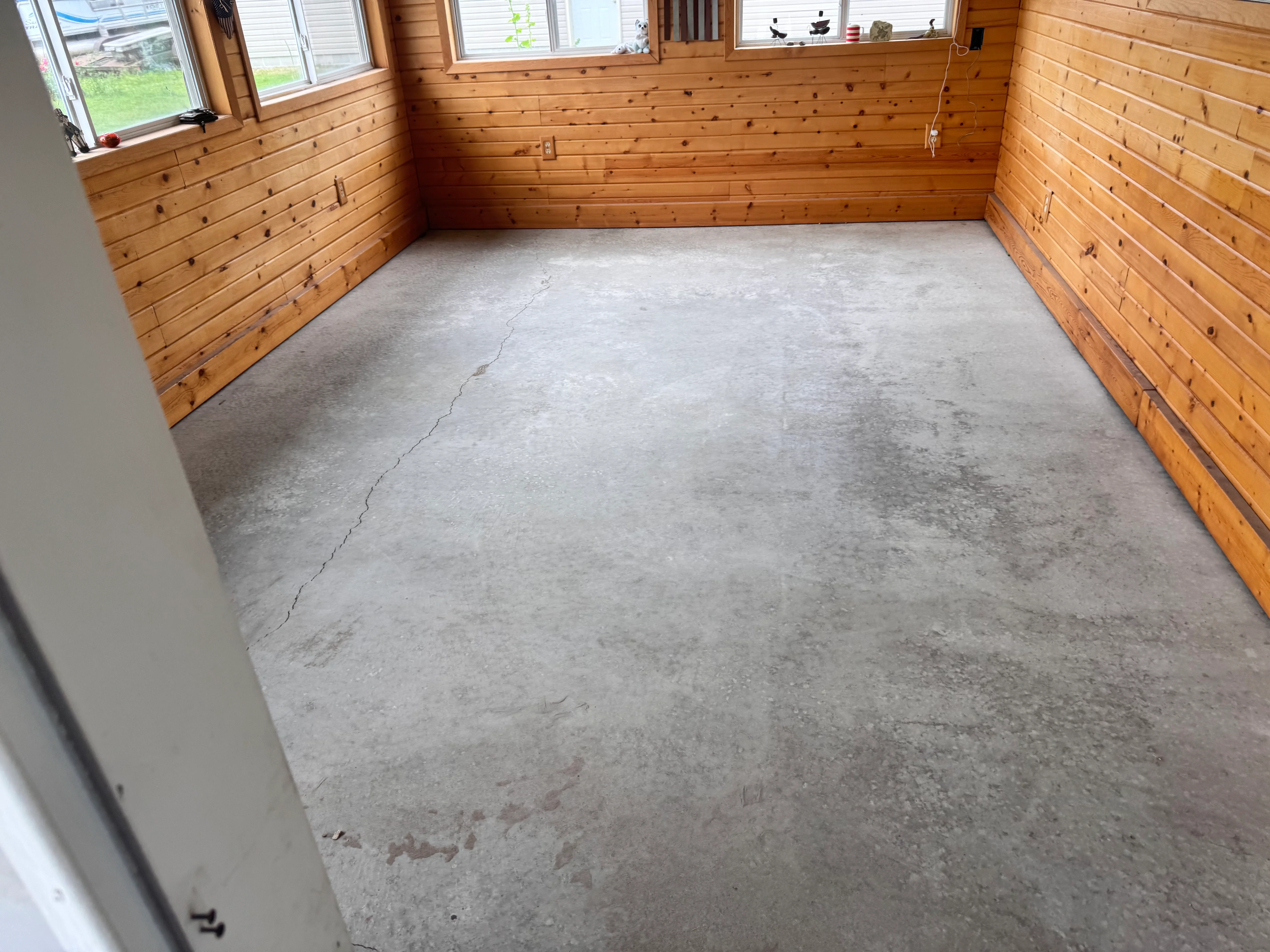 Prepared concrete floor in wood-lined room ready for epoxy coating
