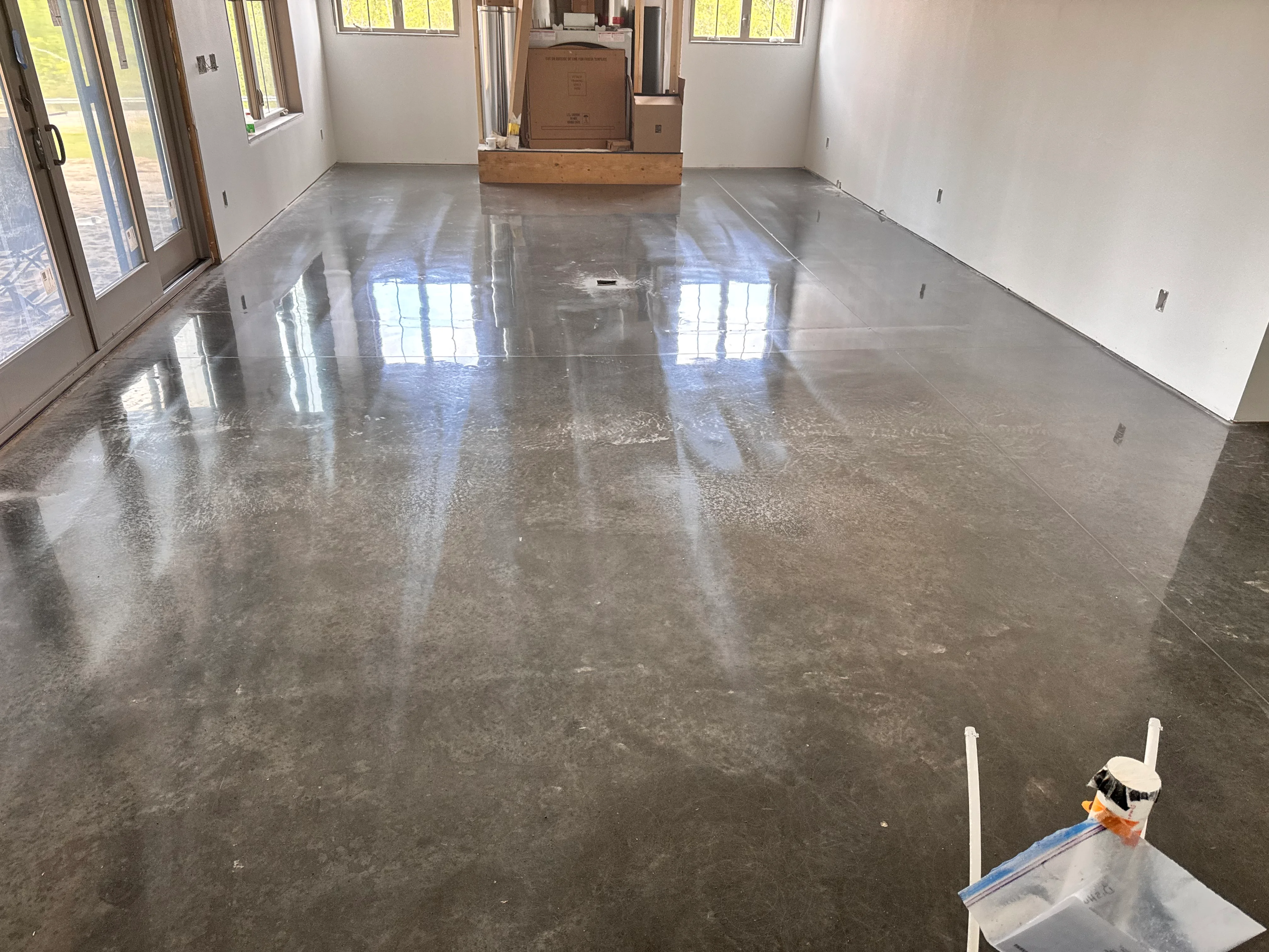 Polished epoxy concrete floor with mirror-like finish reflecting windows and natural light