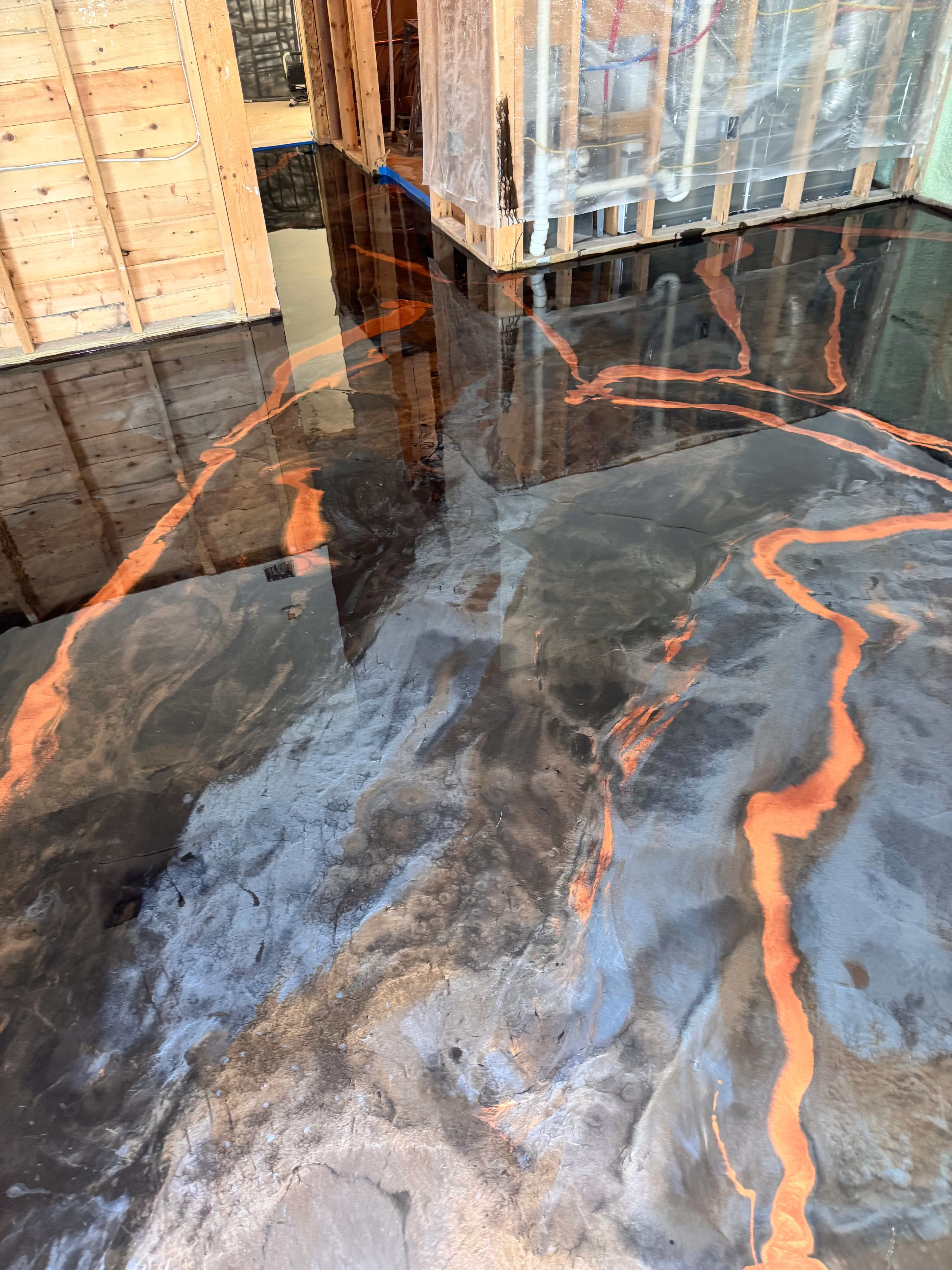 Metallic orange and black swirled epoxy floor with high-gloss finish in garage