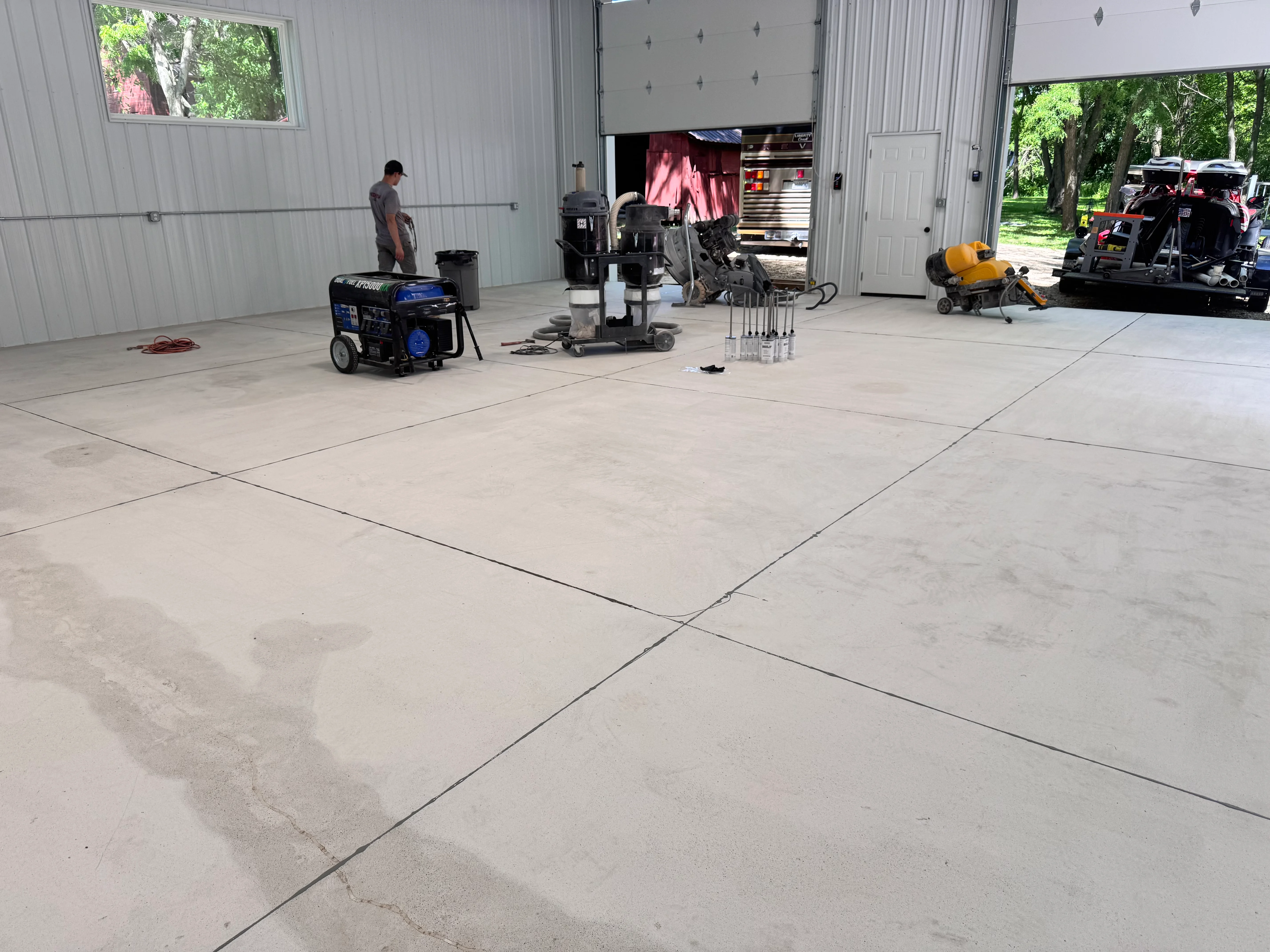 Commercial garage with newly installed light gray epoxy flooring and control joints