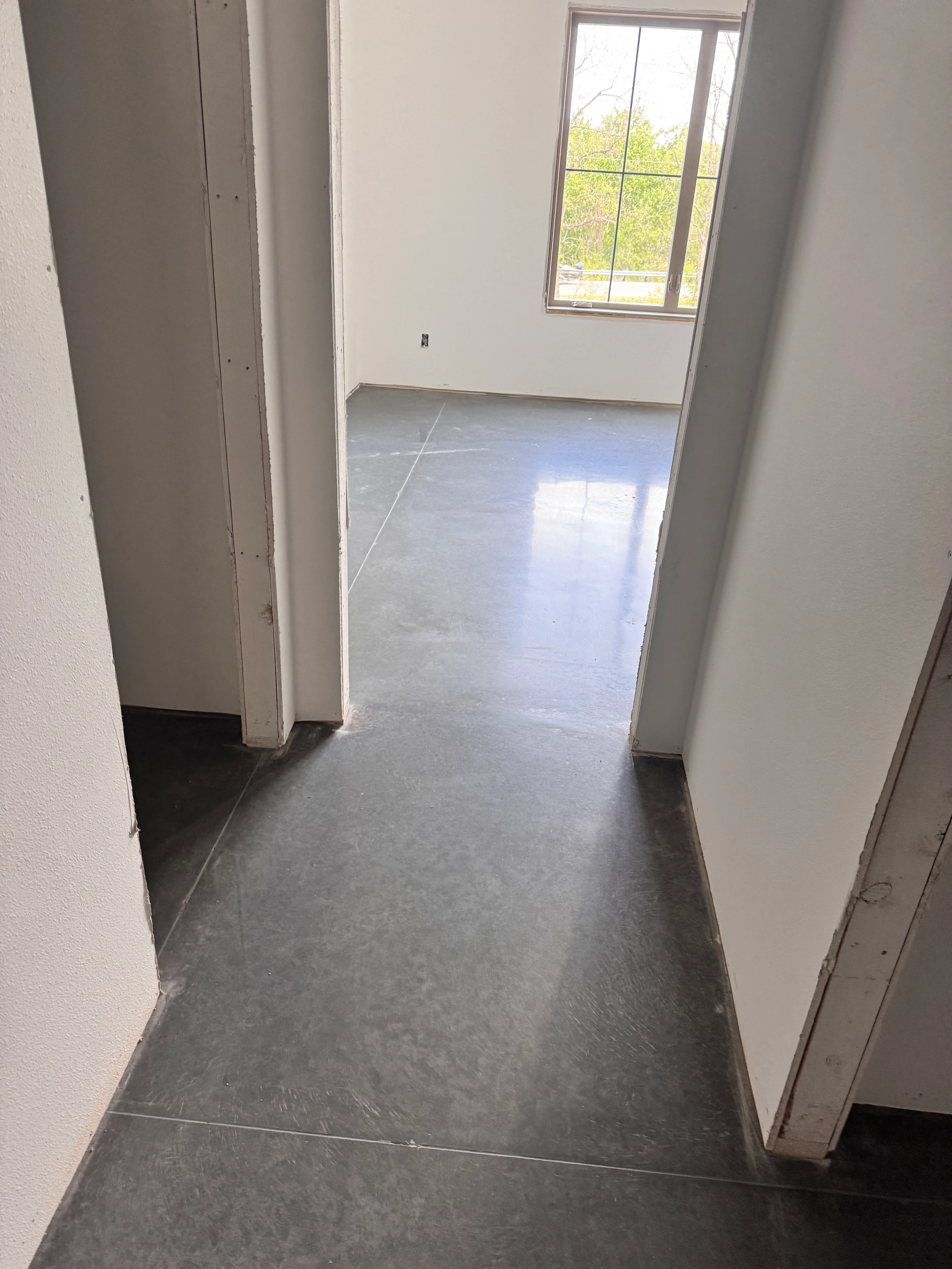 Polished concrete floor with reflective finish in bright interior space with windows