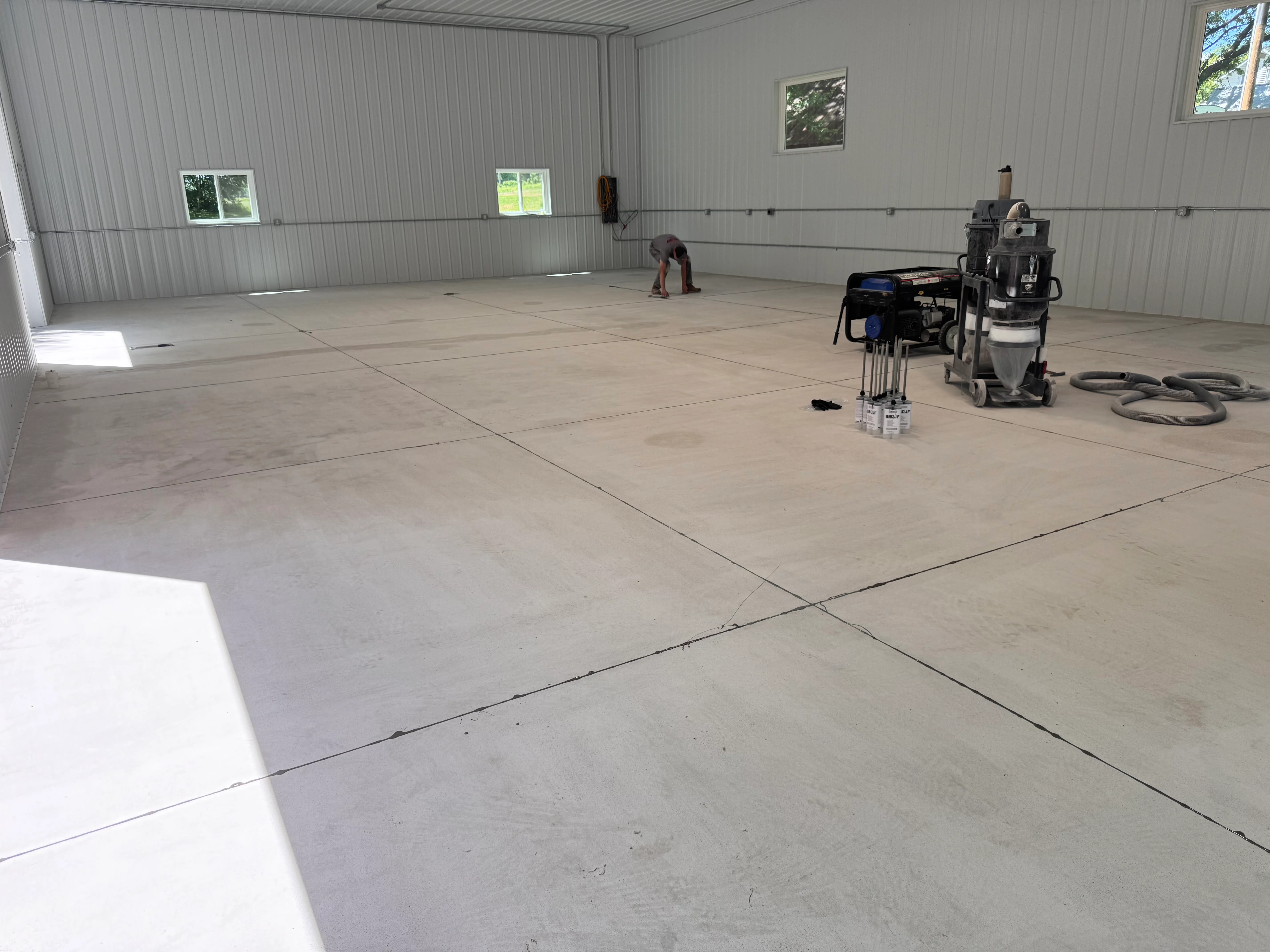 Commercial garage with epoxy flooring installation in progress, metal building interior
